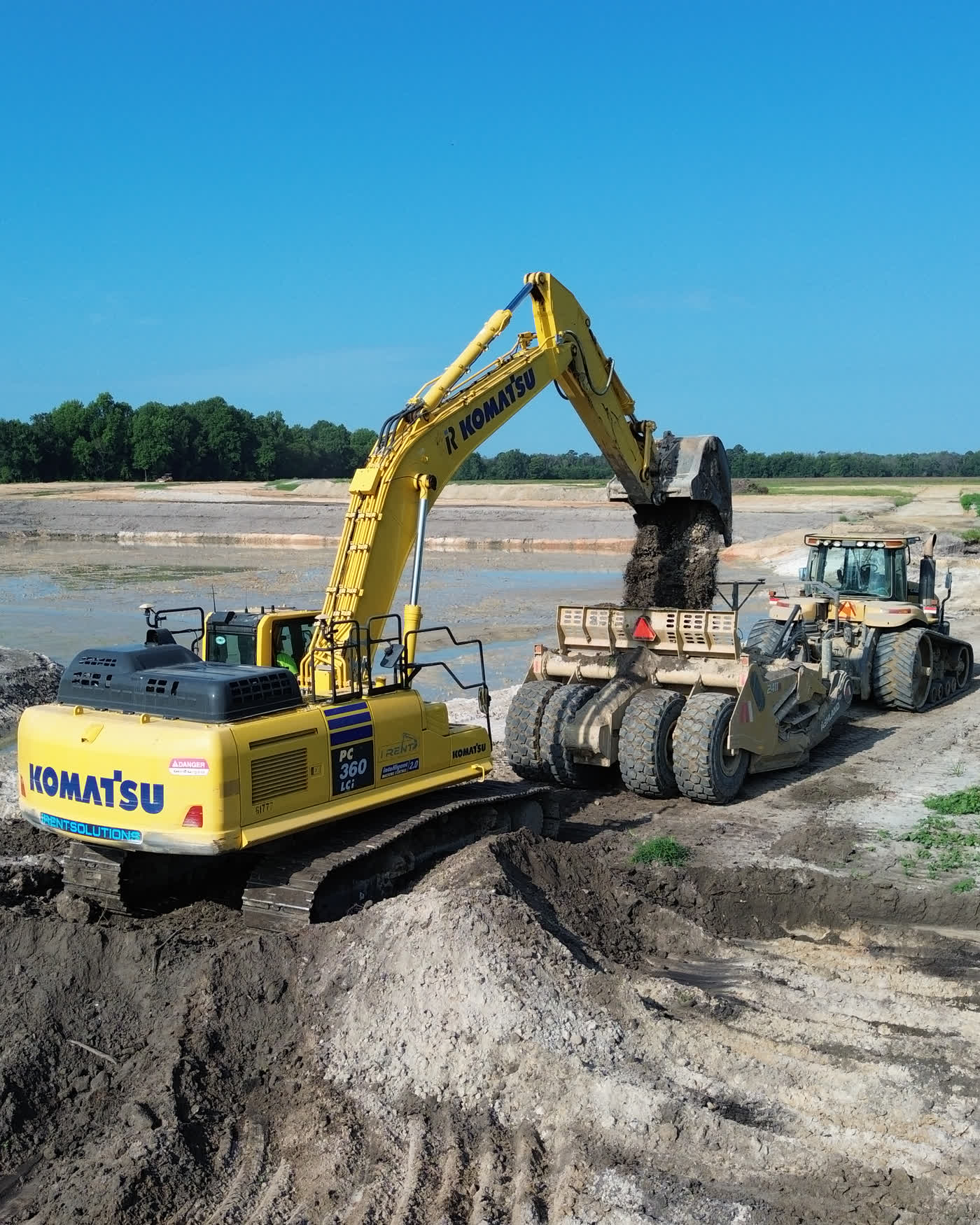 A Komatsu PC360LC excavator loading a haul truck during earthwork at the Allen Farms development